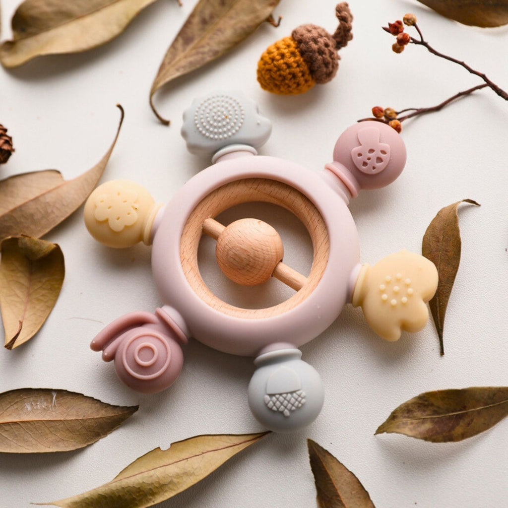 Baby silicone teether color pink with wooden ring and rattle